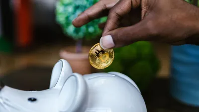 Pessoa economizando dinheiro em um cofrinho