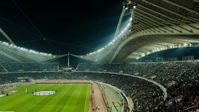 Estádio de futebol iluminado à noite para transmissão ao vivo